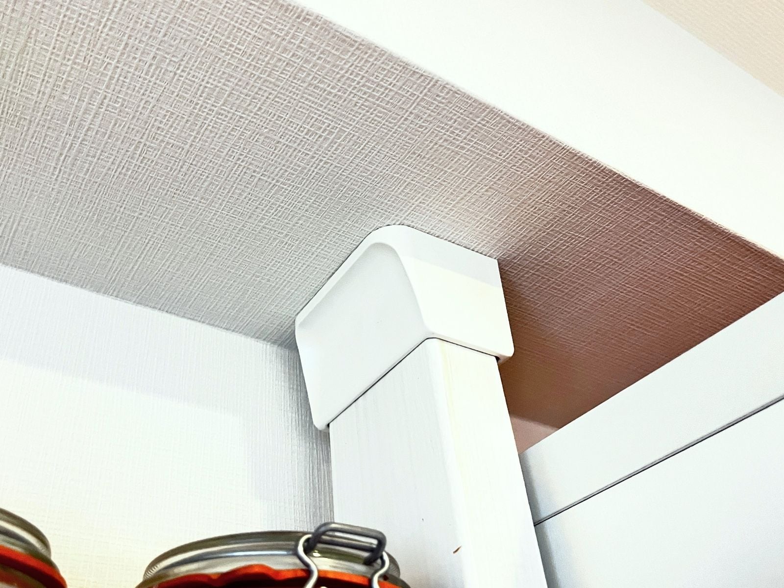 The top of a 2x4 post, with a white Diawall cap pressed against the ceiling