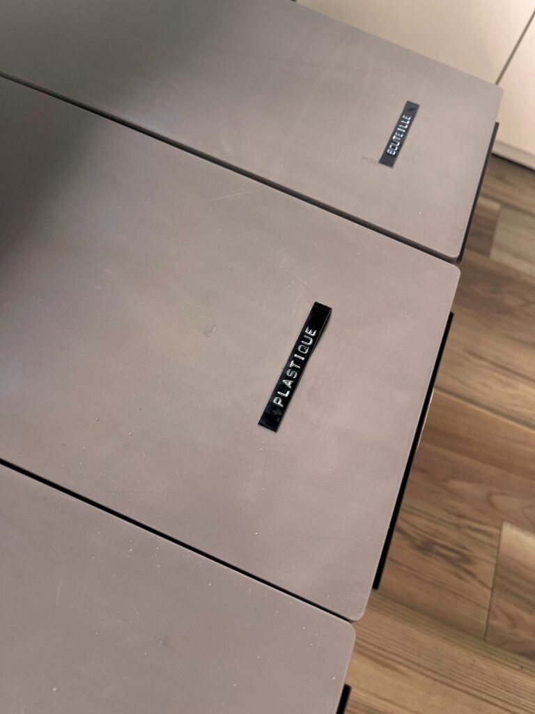 Embossed French labels reading PLASTIQUE and BOUTEILLE on the lids of two trash cans