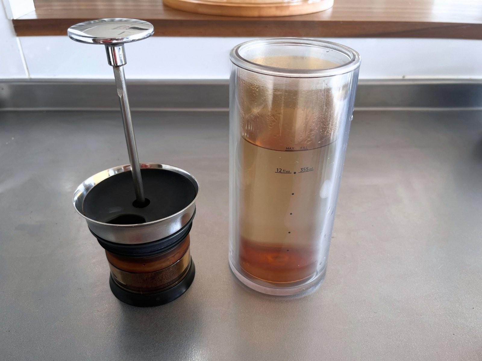 The American Press plunger with the coffee-filled pod, next to the carafe of hot water
