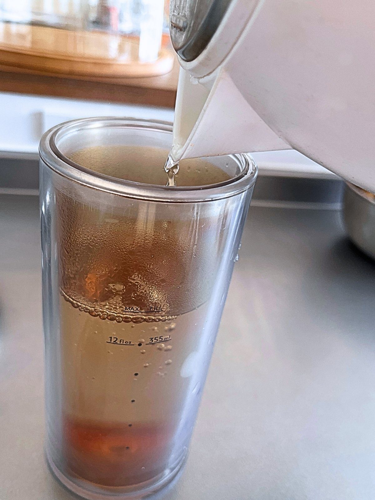 Pouring hot water from a kettle into the American Press carafe, up to the MAX FILL line
