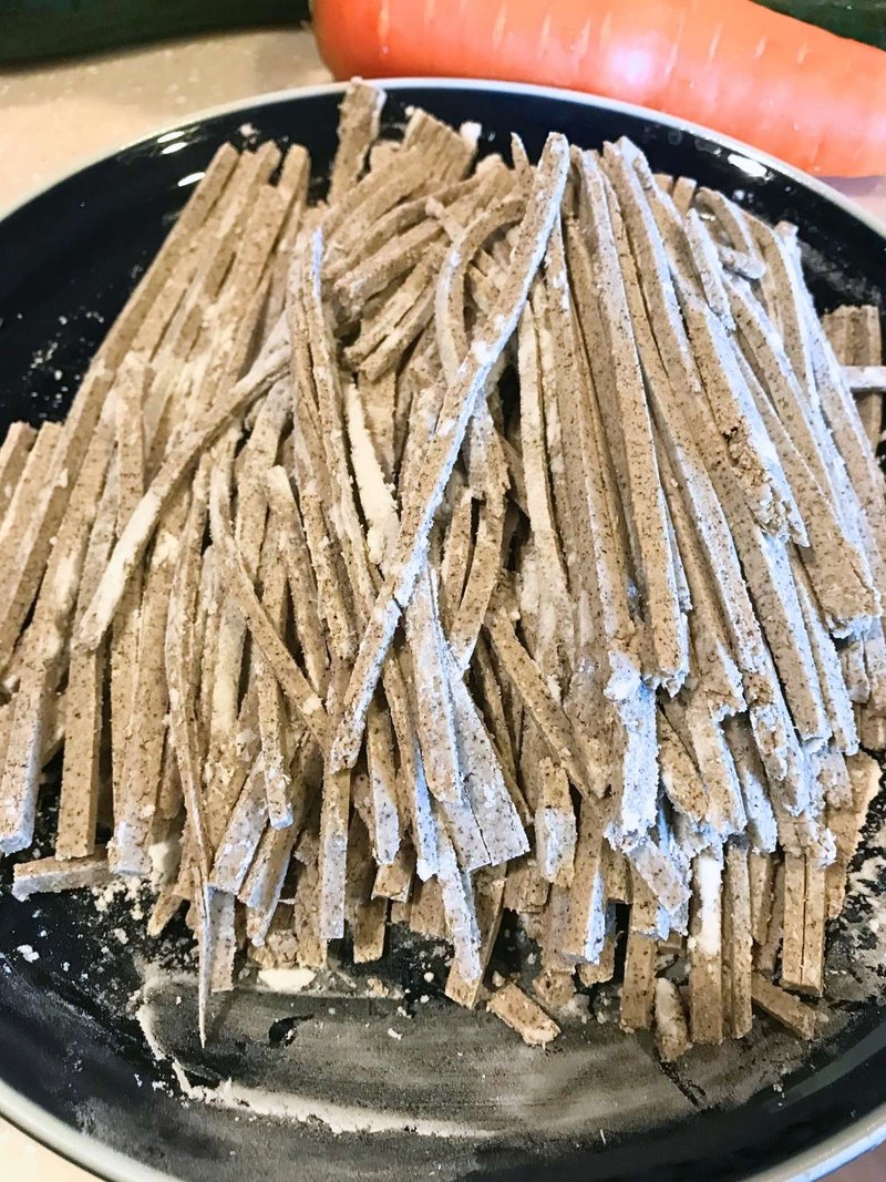 Crumbly homemade buckwheat noodles piled on a plate
