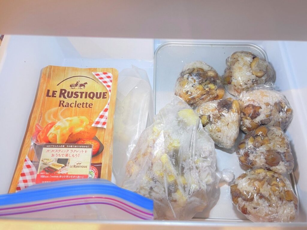 Wrapped rice balls and a bag of frozen chestnuts in a freezer drawer