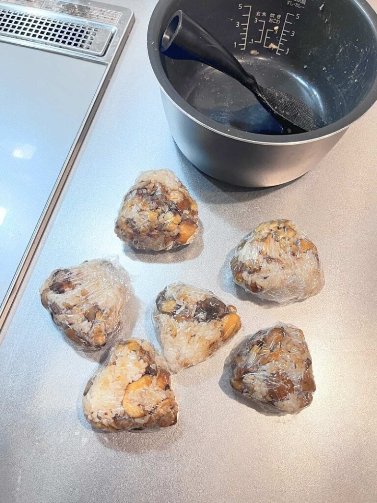 Six triangular rice balls wrapped in plastic wrap