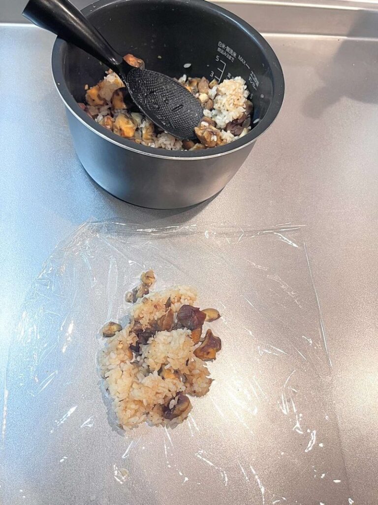 Chestnut rice on a sheet of plastic wrap, ready to be shaped into a rice ball
