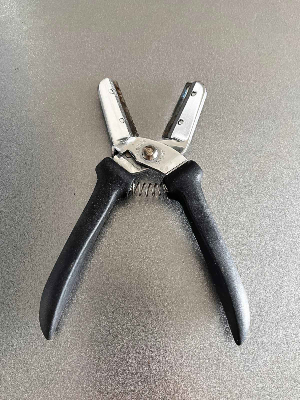 The chestnut peeler opened, showing the serrated blade and the straight cutting blade in a V shape