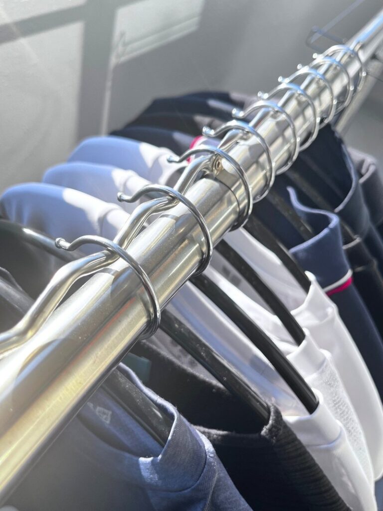 Hangers sitting one per dip in the wavy wire along the top of a drying pole