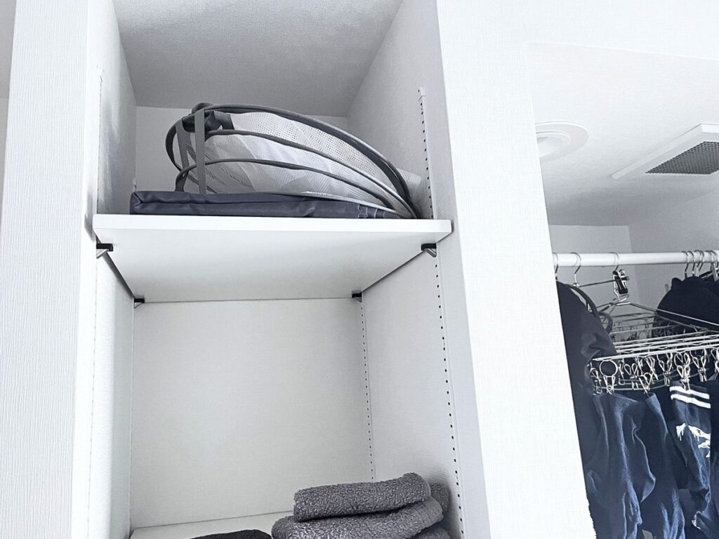 A folded mesh drying rack stored on an upper shelf
