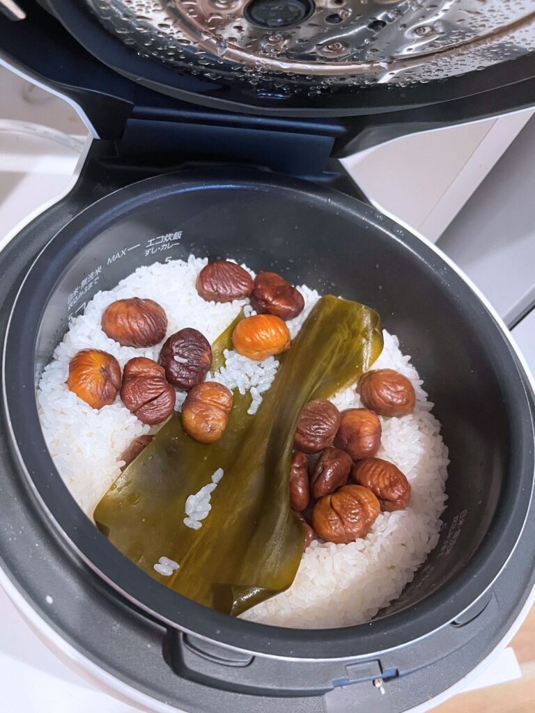 Cooked chestnut rice in the rice cooker, with the chestnuts and kombu on top
