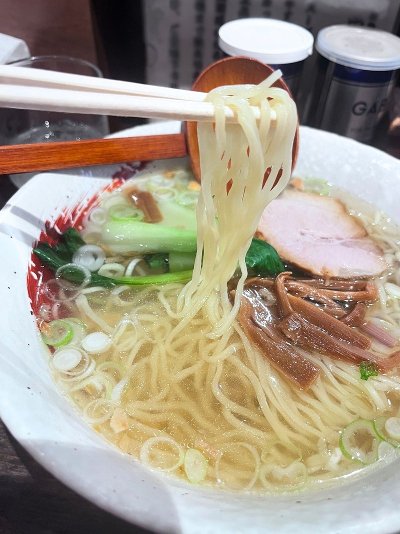Lifting noodles with chopsticks and a wooden spoon