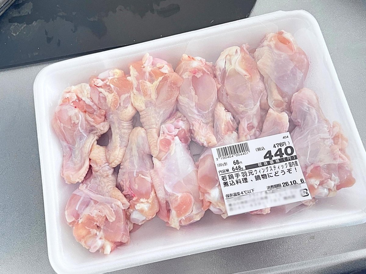 A tray of raw chicken drumettes on a kitchen counter